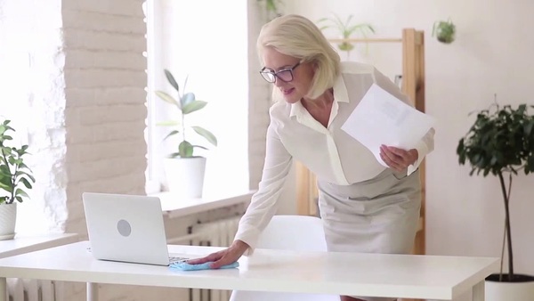 Adults working at a tidy desk in a bright, neutral office